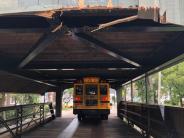 The bridge being damaged by a school bus driving through it. 